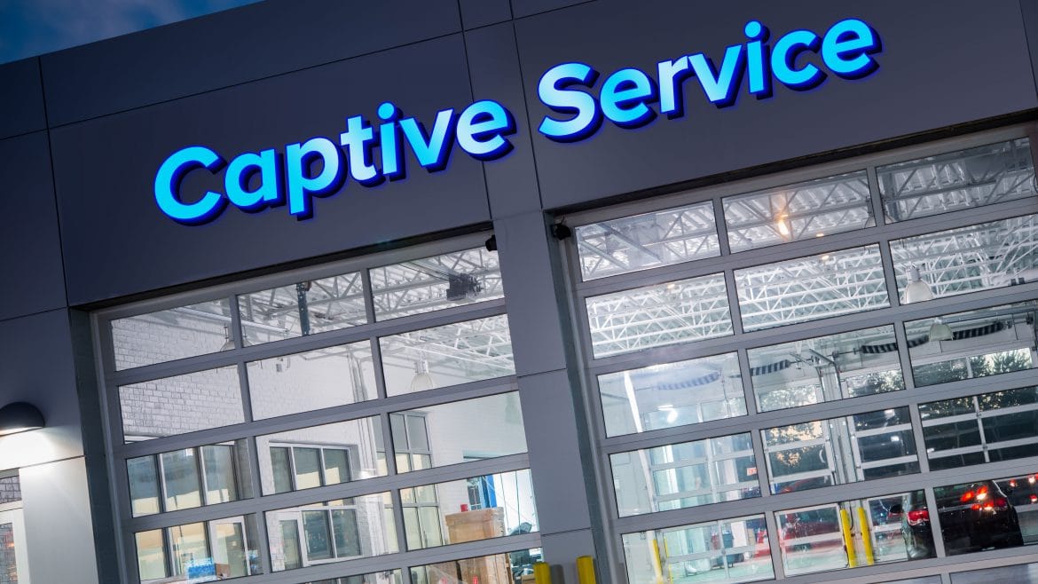 Image of a vehicle service facility at night with Captive Service sign lighted above doors