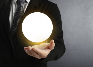 Man in suit holding glowing orb in palm